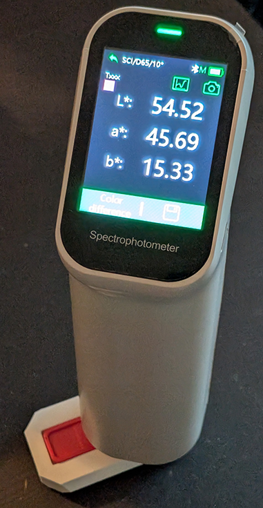 A picture of a spectrophotometer measuring a swatch.