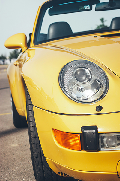 A picture of a yellow sports car parked in a parking lot.